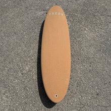 Load image into Gallery viewer, Cork surfboard deck with 'PREDN' branding on a gray concrete surface